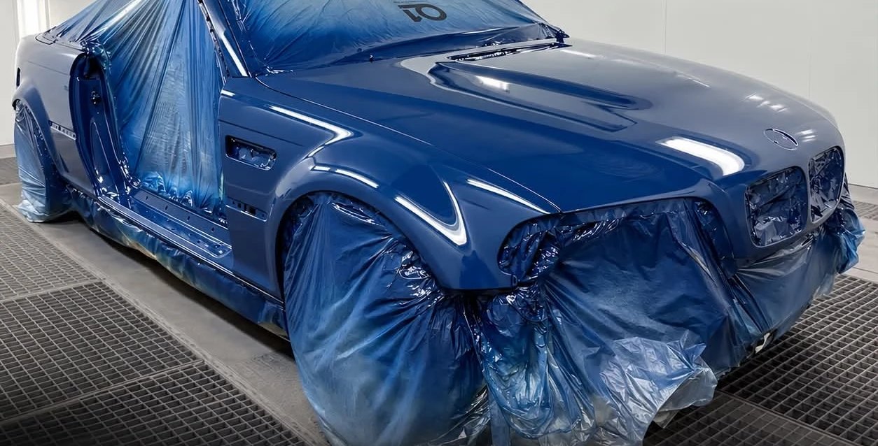 A BMW M3 masked up in the paint booth during a full respray.